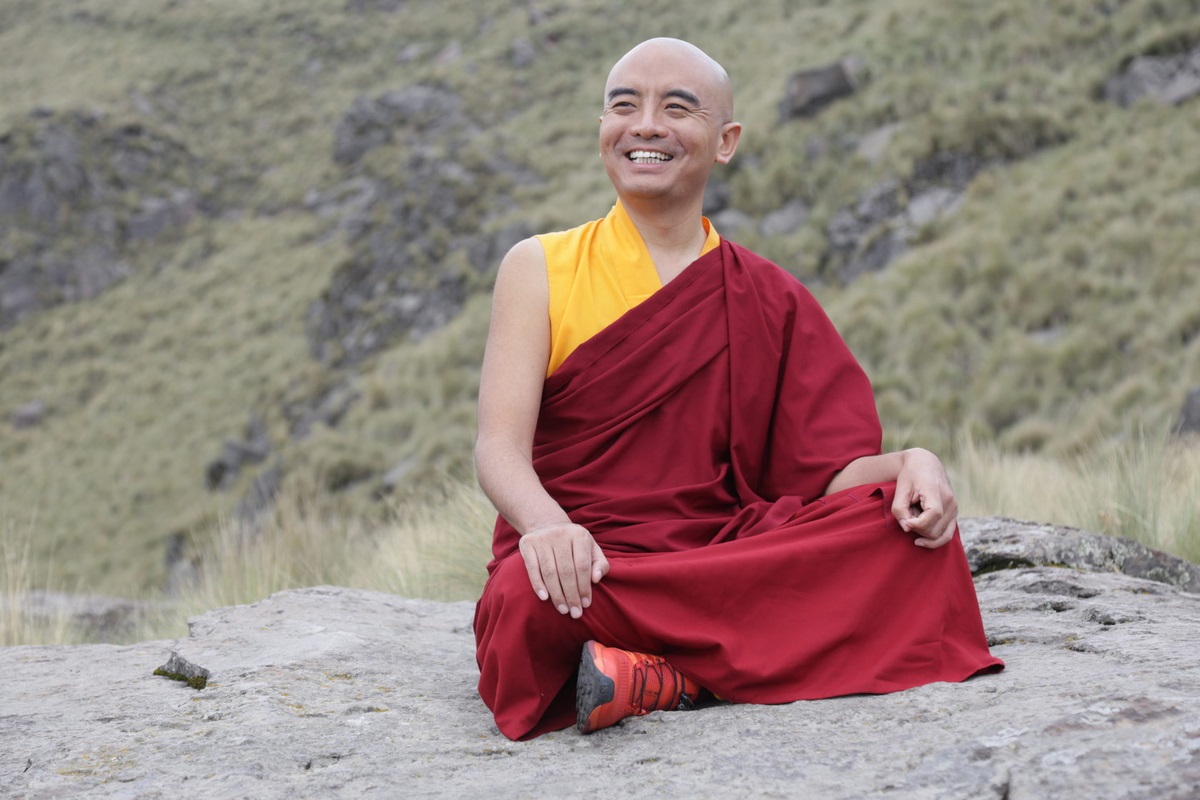 Tibetaanse monnik zit en glimlacht